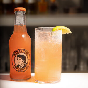 bicchiere cocktail Espolon Paloma con accanto bottiglia di ginger beer