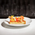 Pane-tostato,-sgombro-affumicato,-pomodoro-Pachino-IGP-e-basilico su piatto